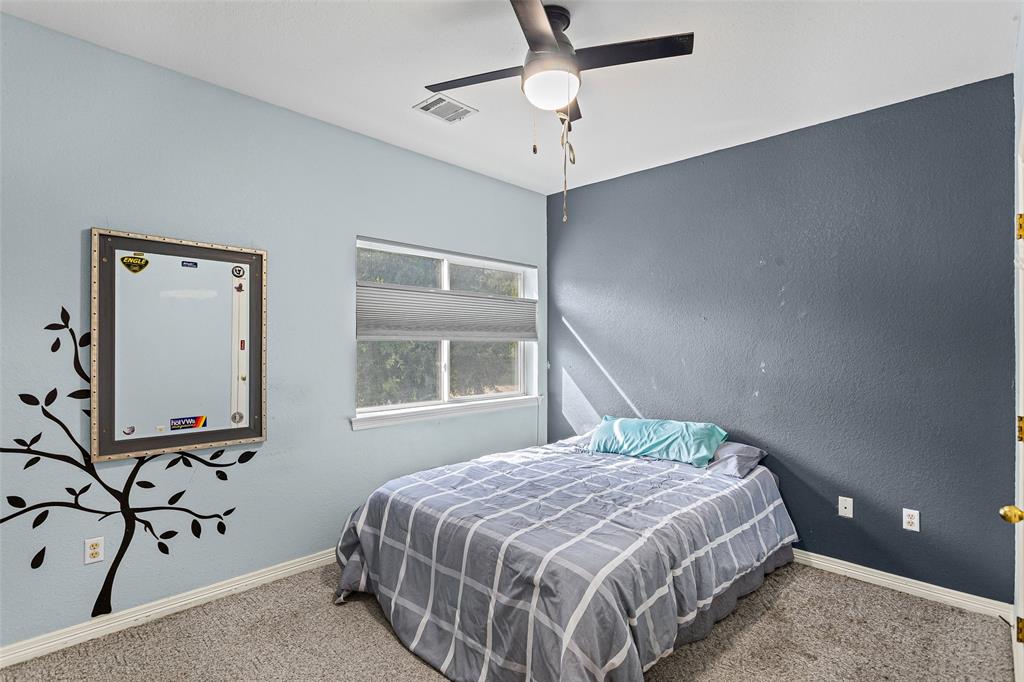 Room with dual-toned painted walls, carpeted flooring, single-window with integrated shade, and ceiling fan with light fixture