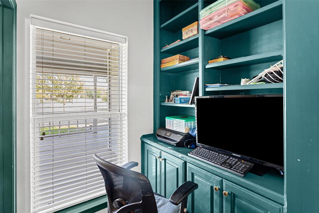 Built-in floor-to-ceiling shelving, custom cabinetry with shaker-style doors, and a double-hung window featuring adjustable horizontal blinds