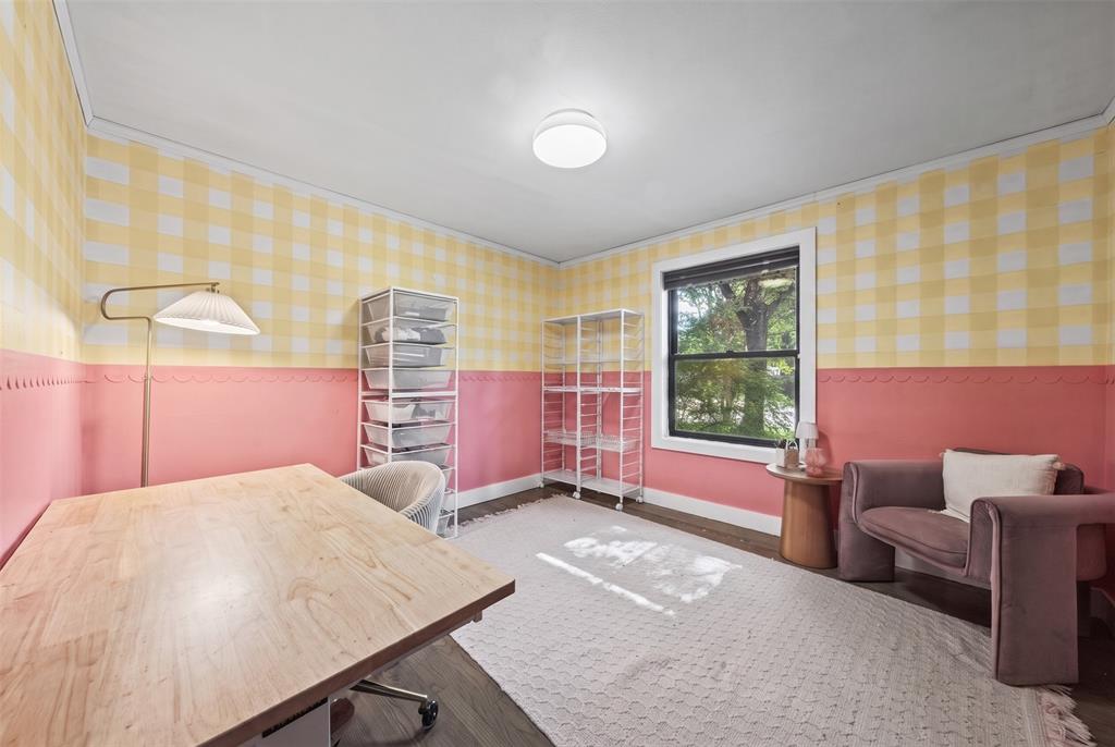 Room featuring dual-tone walls with gingham wallpaper, scalloped trim detailing, wood-finish flooring, and a single-pane window