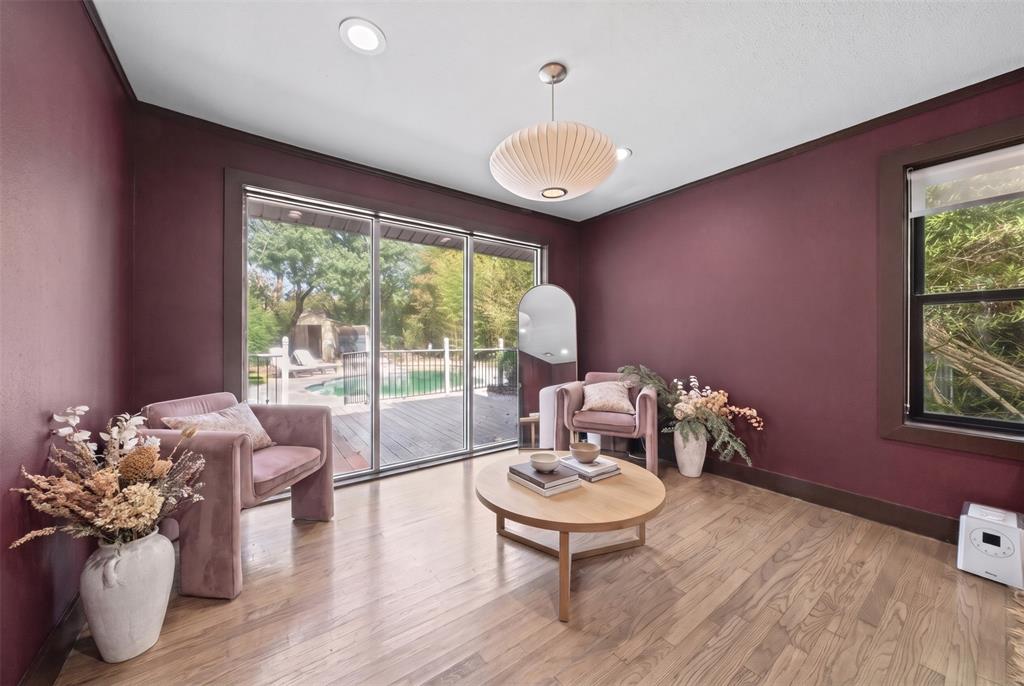 Wood-finish flooring, sliding glass door, recessed lighting, pendant light fixture, and dark-toned wall trim