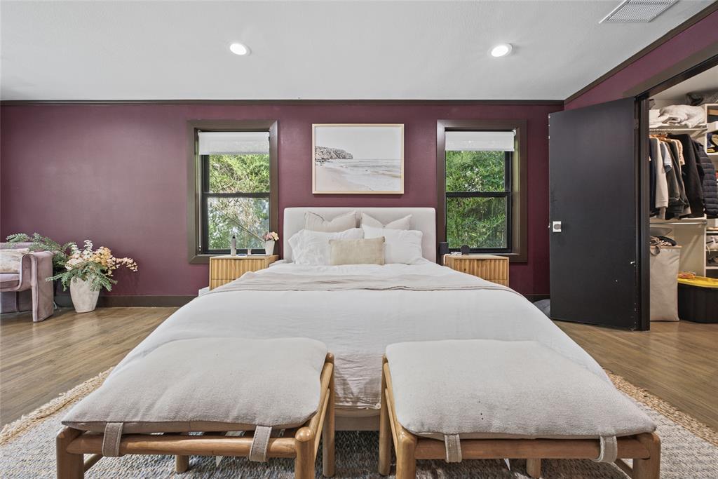 Wood-finish flooring, dual windows with roller shades, and a built-in closet with integrated storage system