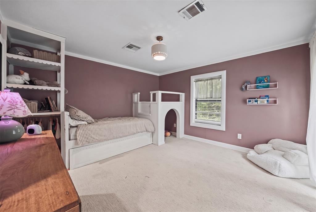 Built-in white shelving unit, custom white millwork structure, wall-mounted floating shelves, neutral wall-to-wall carpeting, and center-mount flush light fixture