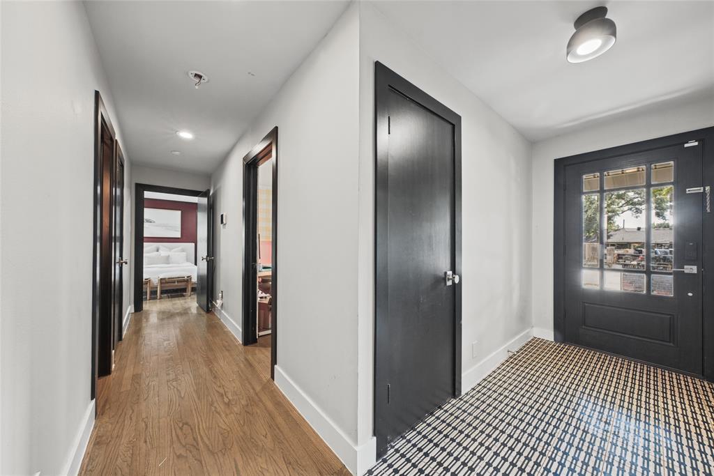 Entryway featuring a multi-pane glass entry door, dark-finished interior door trim, wood-finish flooring, and recessed ceiling lighting