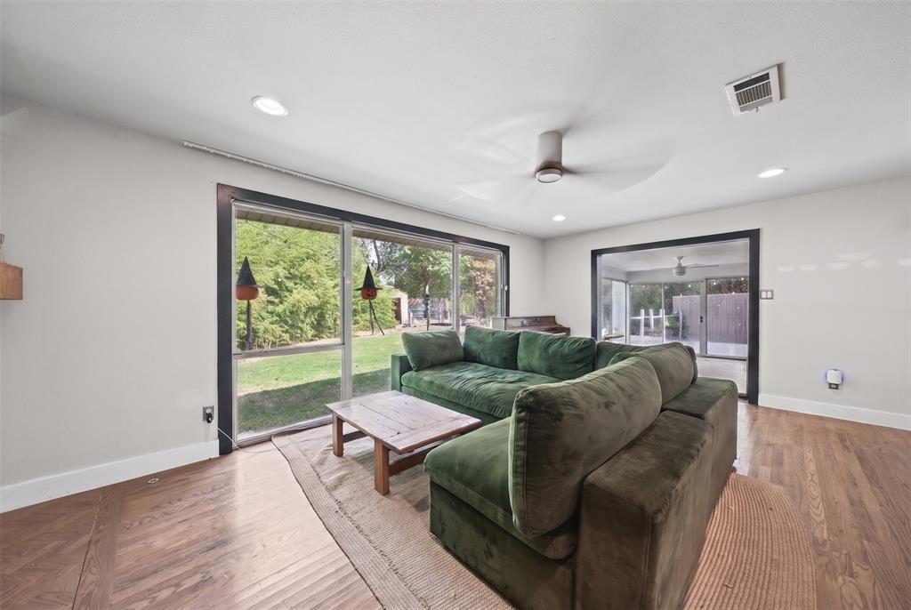 Living area featuring wood-finish flooring, recessed lighting, ceiling fan, and sliding glass doors