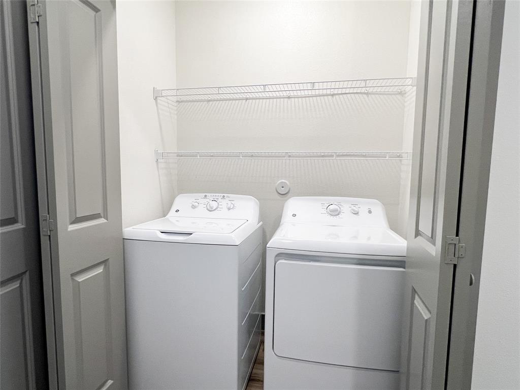 Laundry area with separate washer and dryer and wood finished floors