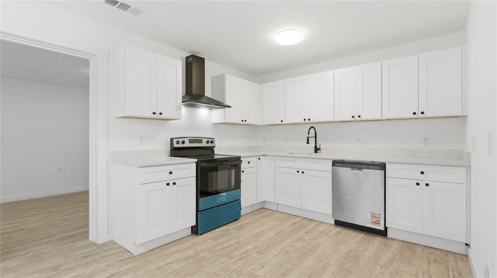 Kitchen featuring white shaker-style cabinetry, solid-surface countertops, wood-finish flooring, a stainless steel dishwasher, and a matte black gooseneck faucet