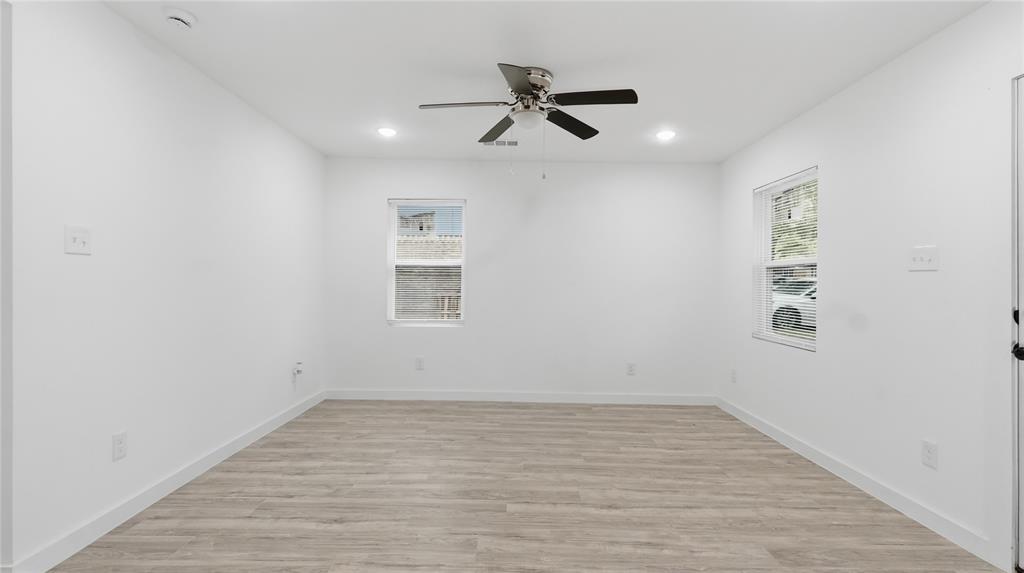 Neutral-toned interior featuring wood-finish flooring, recessed lighting, and a ceiling fan
