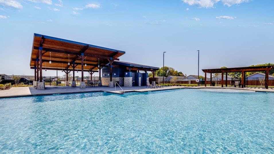 Swimming pool with stone-based support pillars, expansive covered pavilion with wood-plank ceiling, and separate wood-frame pergola