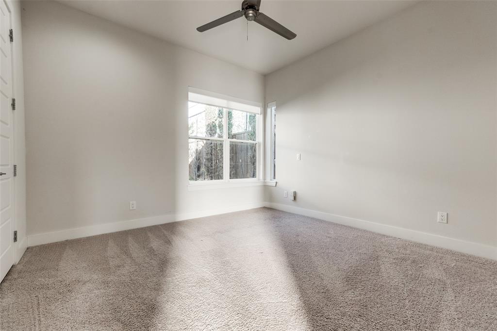 Room featuring wall-to-wall carpeting, neutral paint, multi-pane windows, and a ceiling fan with light fixture