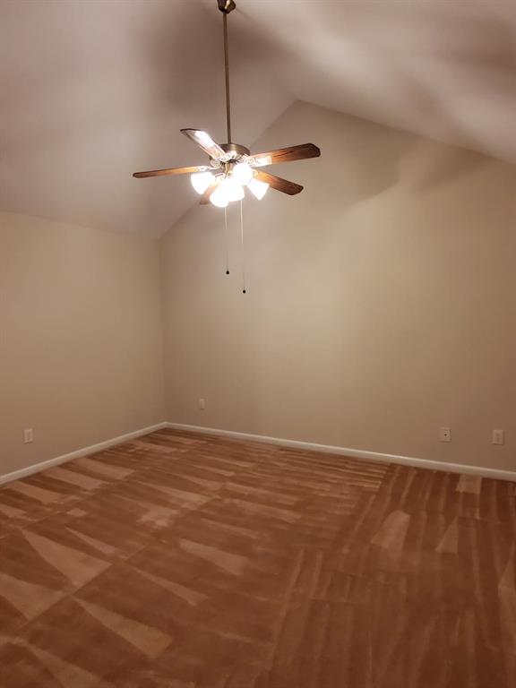 Vaulted ceilings featuring a central five-blade ceiling fan with integrated multi-bulb lighting and wall-to-wall carpeting