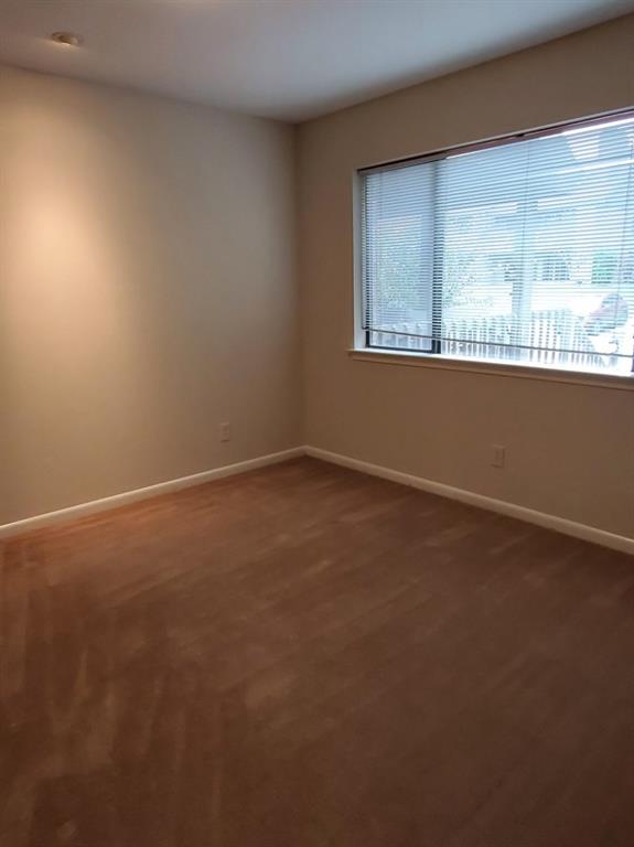 Neutral wall tones, wood-finish flooring, recessed lighting, and a large window with horizontal blinds