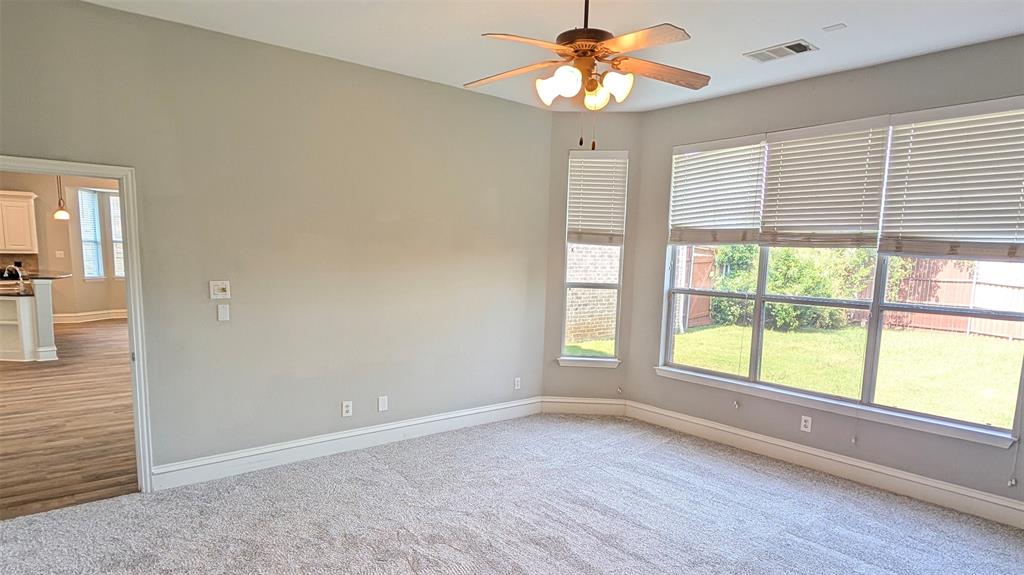 High ceilings featuring a multi-light ceiling fan, expansive windows with horizontal blinds, and neutral carpeting