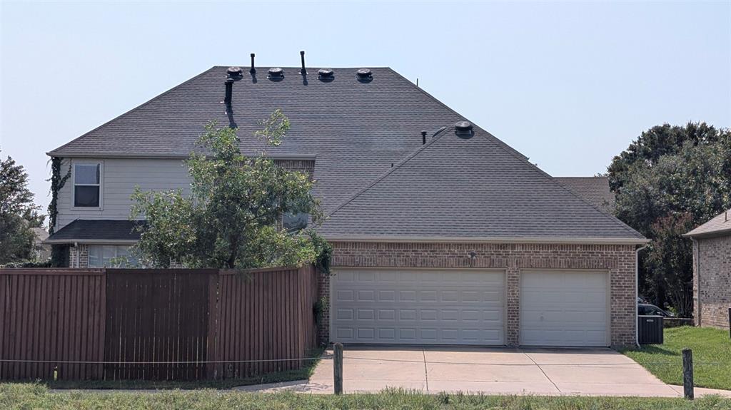 Exterior elevation featuring a brick and siding facade, asphalt shingle roof, two-car garage, and concrete driveway