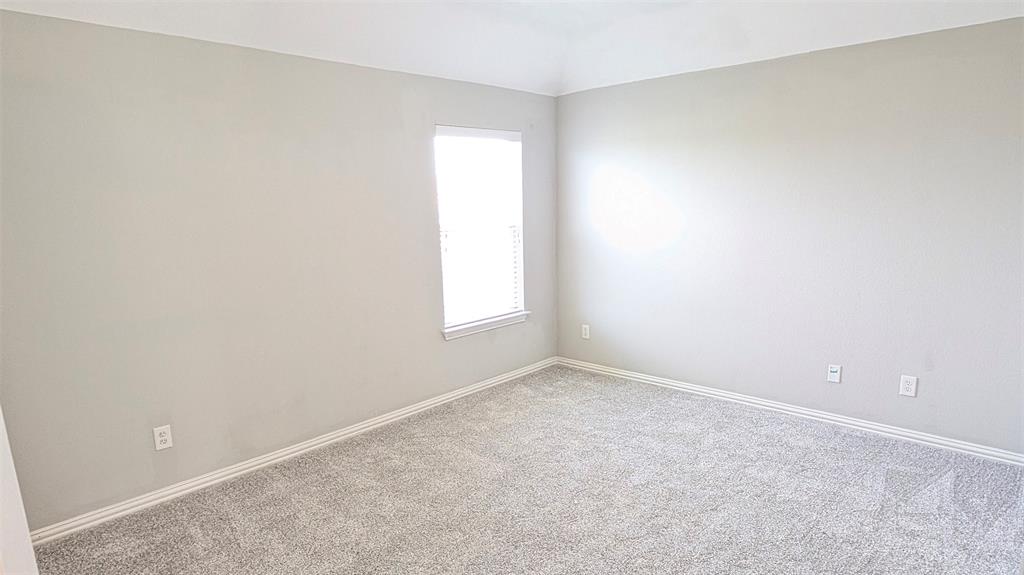 Neutral-toned interior space featuring tray ceilings, neutral wall paint, and wall-to-wall carpeting