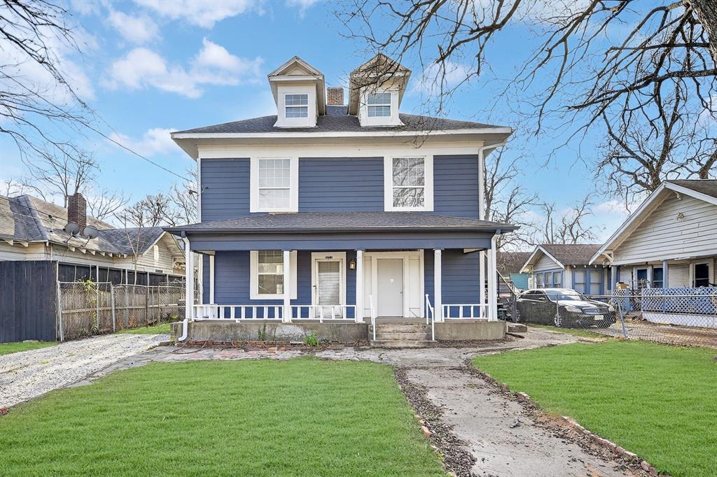 Two-story residence featuring blue horizontal siding, a covered front porch with white railing, and dual dormer windows Two-story residence featuring blue horizontal siding, a covered front porch with white railing, and dual dormer windows
