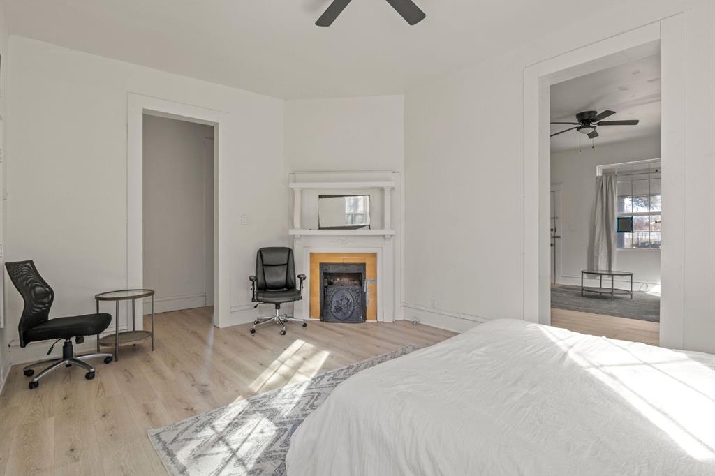 Interior space featuring wood-finish flooring, a corner fireplace with a mantel, and ceiling-mounted fans Interior space featuring wood-finish flooring, a corner fireplace with a mantel, and ceiling-mounted fans