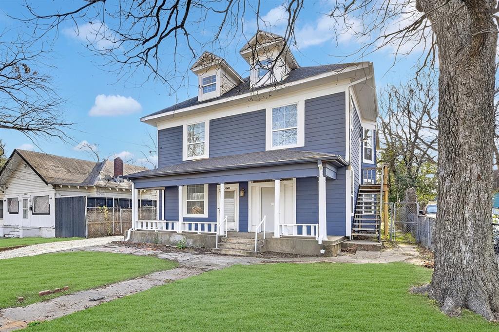 Two-story residence featuring horizontal lap siding, a full-width covered front porch, dual roof dormers, and an exterior metal staircase Two-story residence featuring horizontal lap siding, a full-width covered front porch, dual roof dormers, and an exterior metal staircase