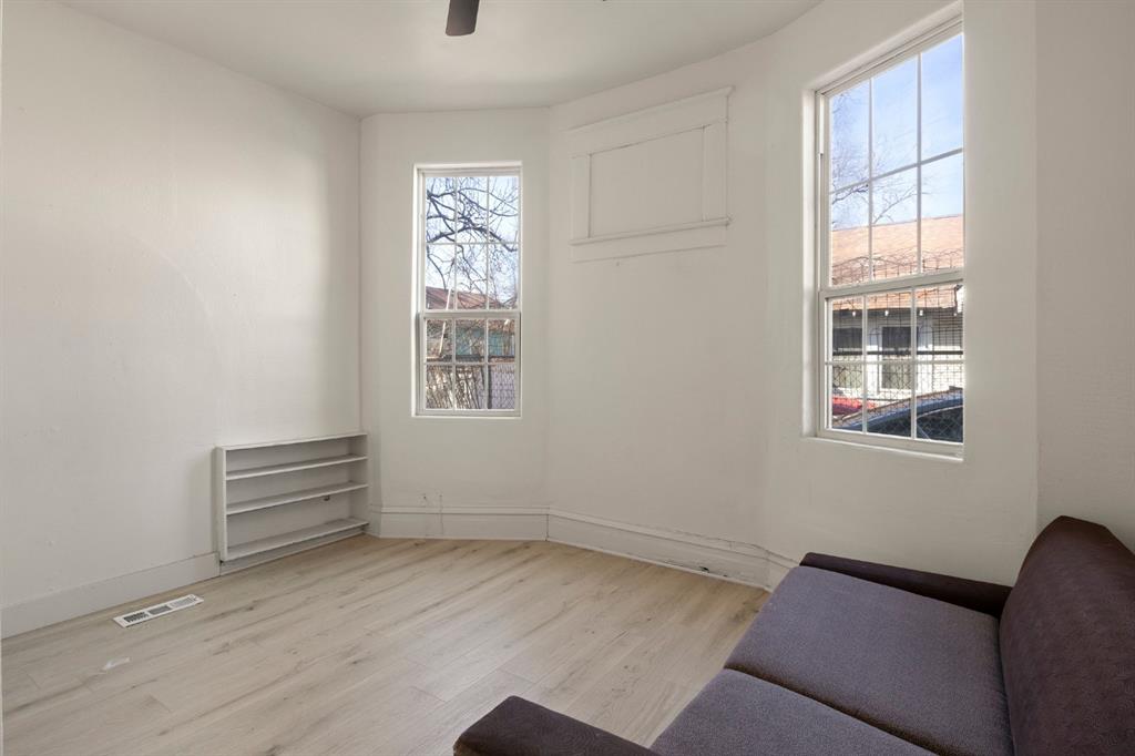 Bay window featuring multi-pane glass, wood-finish flooring, and built-in wall shelving Bay window featuring multi-pane glass, wood-finish flooring, and built-in wall shelving