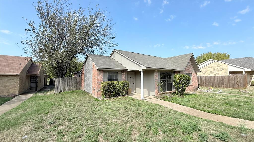 Single-story residence featuring a combination brick and siding exterior, a gabled roofline, a covered front entryway, and wood fencing