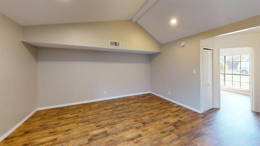 Vaulted ceiling featuring recessed lighting, wood-finish flooring, and a closet with a bi-fold door