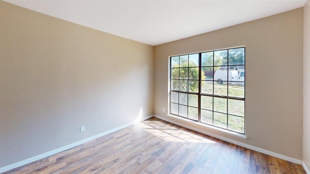 Neutral wall tones paired with wood-finish flooring and a multi-pane window with dark framing Neutral wall tones paired with wood-finish flooring and a multi-pane window with dark framing
