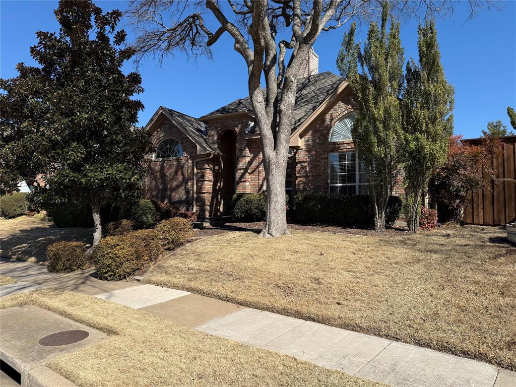 Brick exterior featuring an arched entryway, gabled rooflines, and decorative arched windows