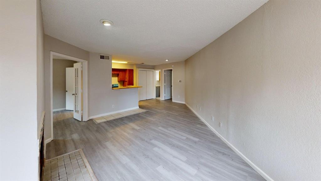 Open-concept interior featuring wood-finish flooring, recessed lighting, and a kitchen service counter
