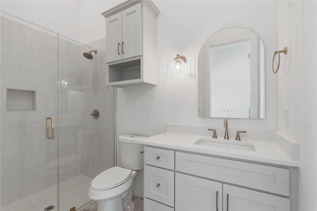 Bathroom featuring a glass-enclosed shower with tile surround, a built-in shower niche, and brushed nickel fixtures