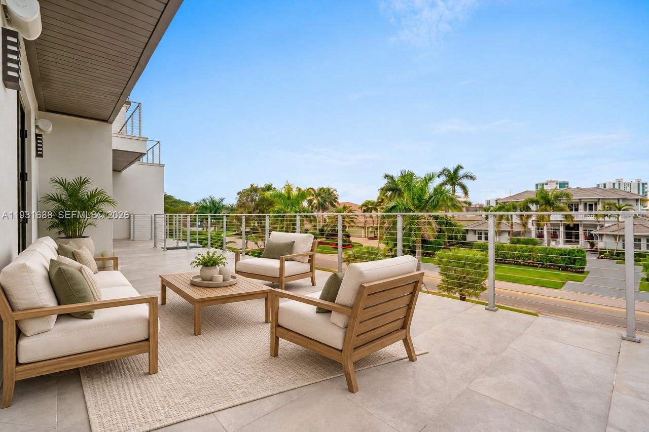 Covered outdoor terrace featuring large-format stone tile flooring and a horizontal cable railing system