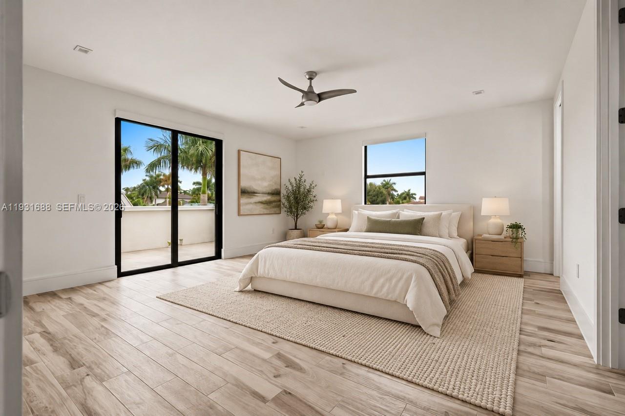 Room featuring light wood-finish flooring, recessed lighting, a modern ceiling fan, and black-framed glass sliding doors opening to a balcony