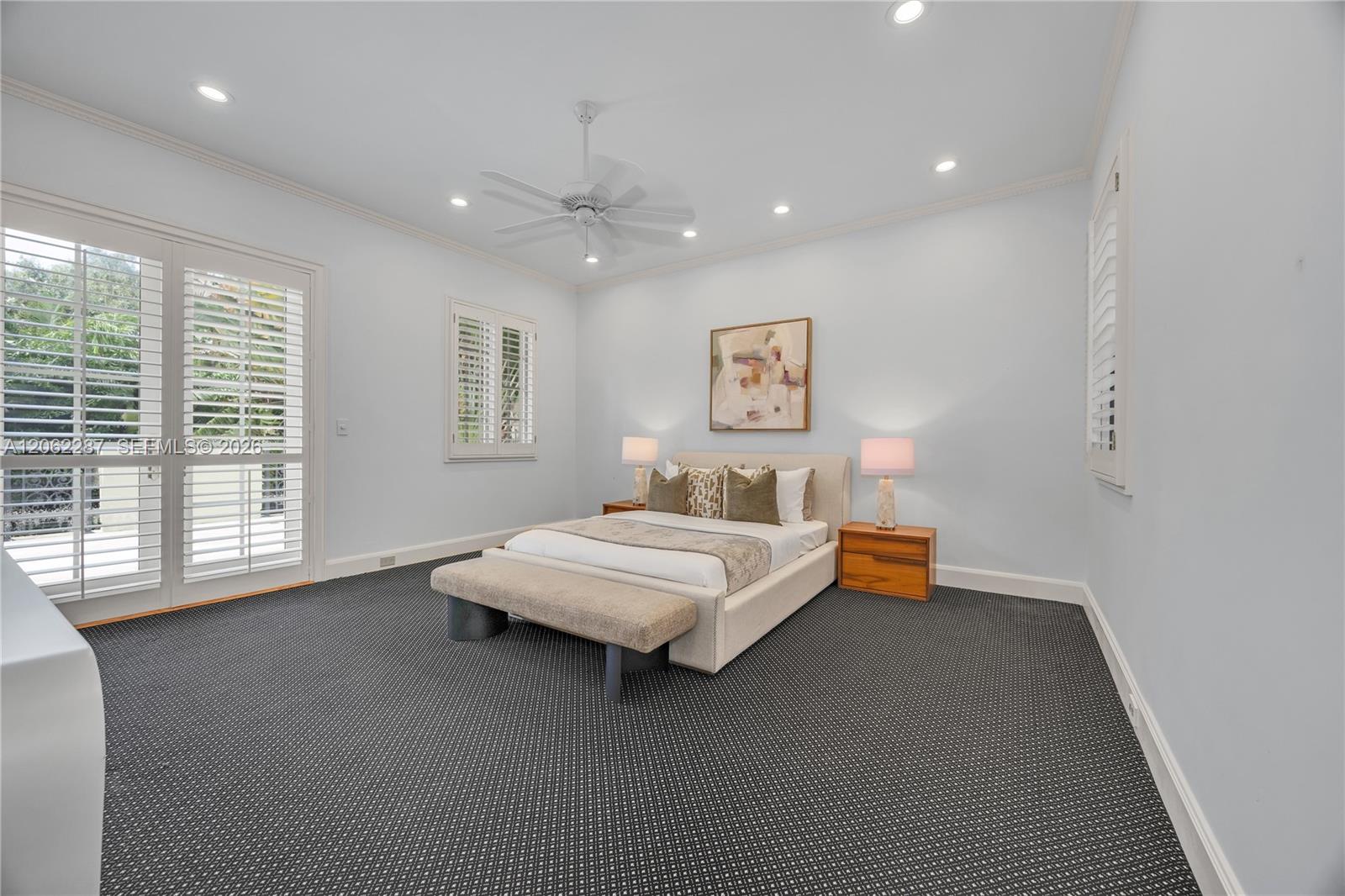 Spacious room featuring high ceilings with recessed lighting, integrated ceiling fan, plantation shutters, and double glass-paned doors