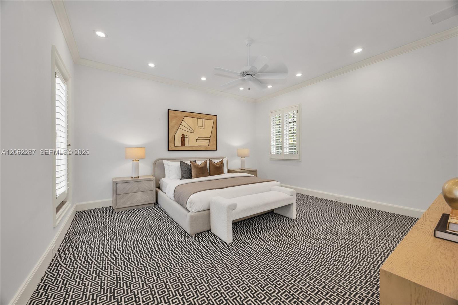 Spacious bedroom featuring recessed lighting, a ceiling fan with integrated lighting, patterned wall-to-wall carpeting, and plantation shutters