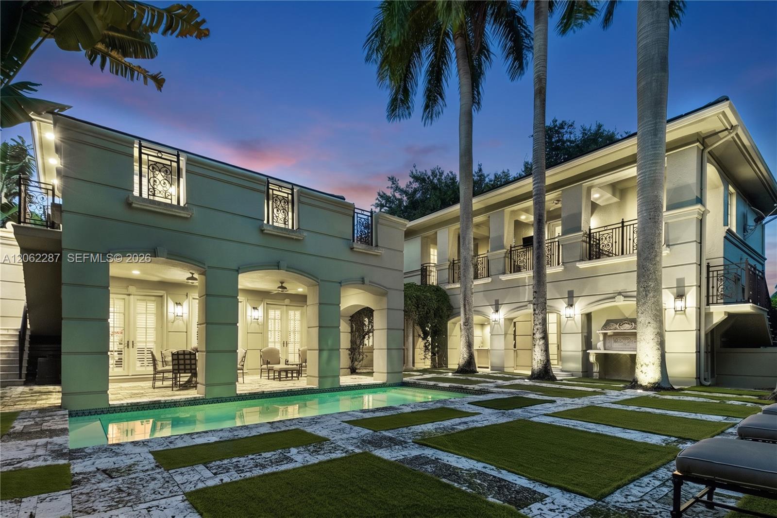 Exterior featuring a pool with stone hardscaping, recessed covered loggias, two-story balconies with ornate metal railings, and a built-in outdoor grill station