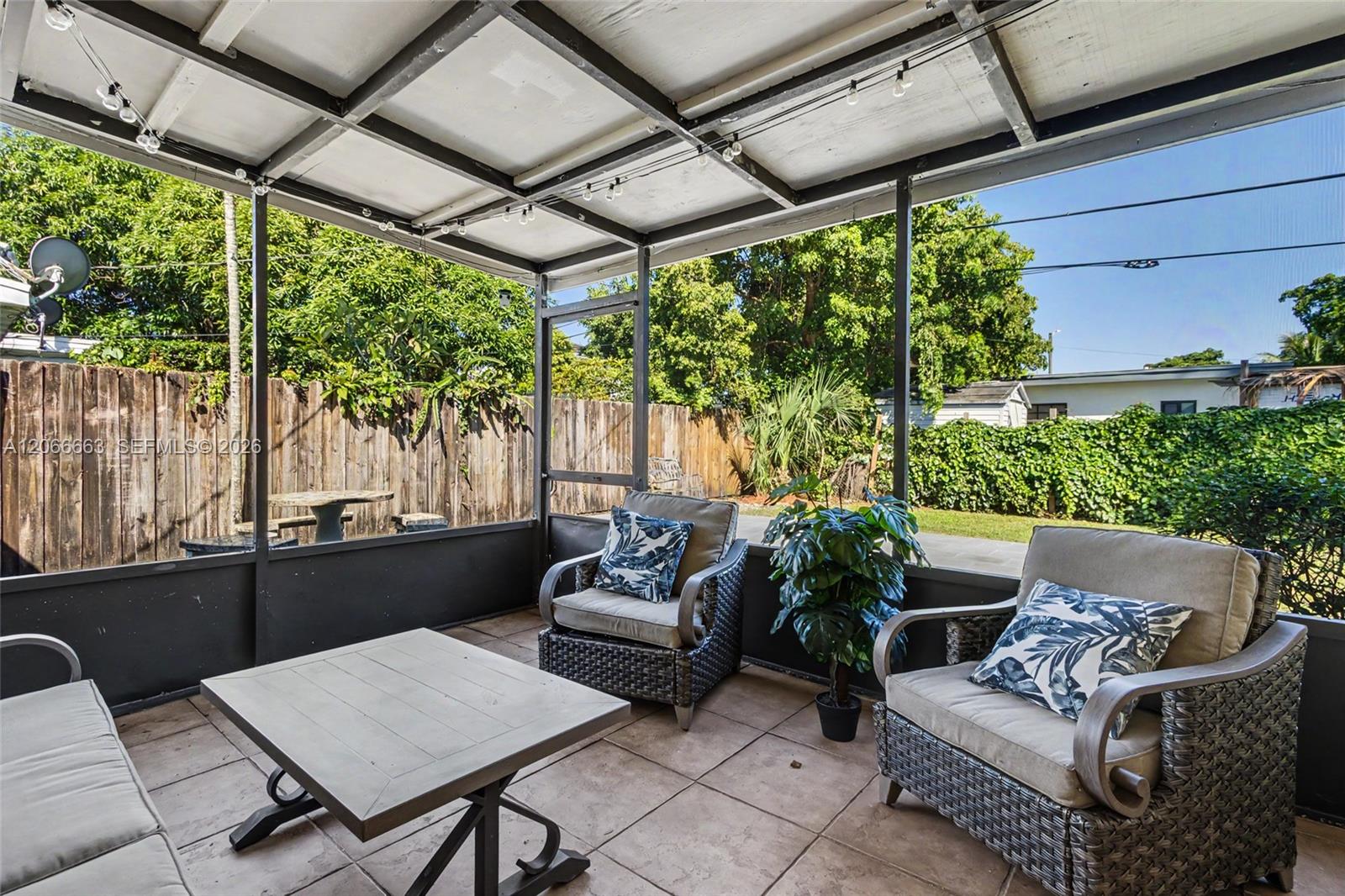 Screened-in porch featuring a metal frame, tile flooring, and wood-panel perimeter fencing
