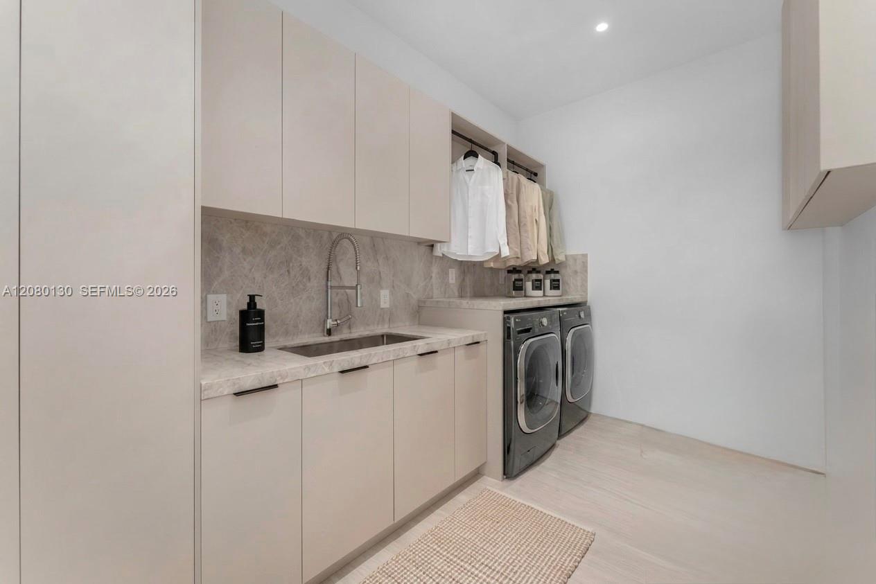 Laudry Room. Disclaimer: Several photographs presented in this listing contain digitally added furniture, artwork, and decor. These virtually staged images are intended solely for illustrative purposes.