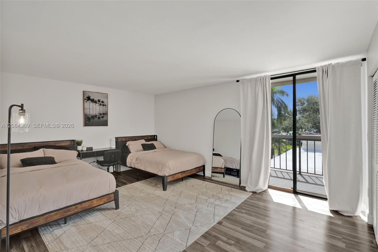 Interior space featuring wood-finish flooring, sliding glass door, and exterior balcony with metal railing