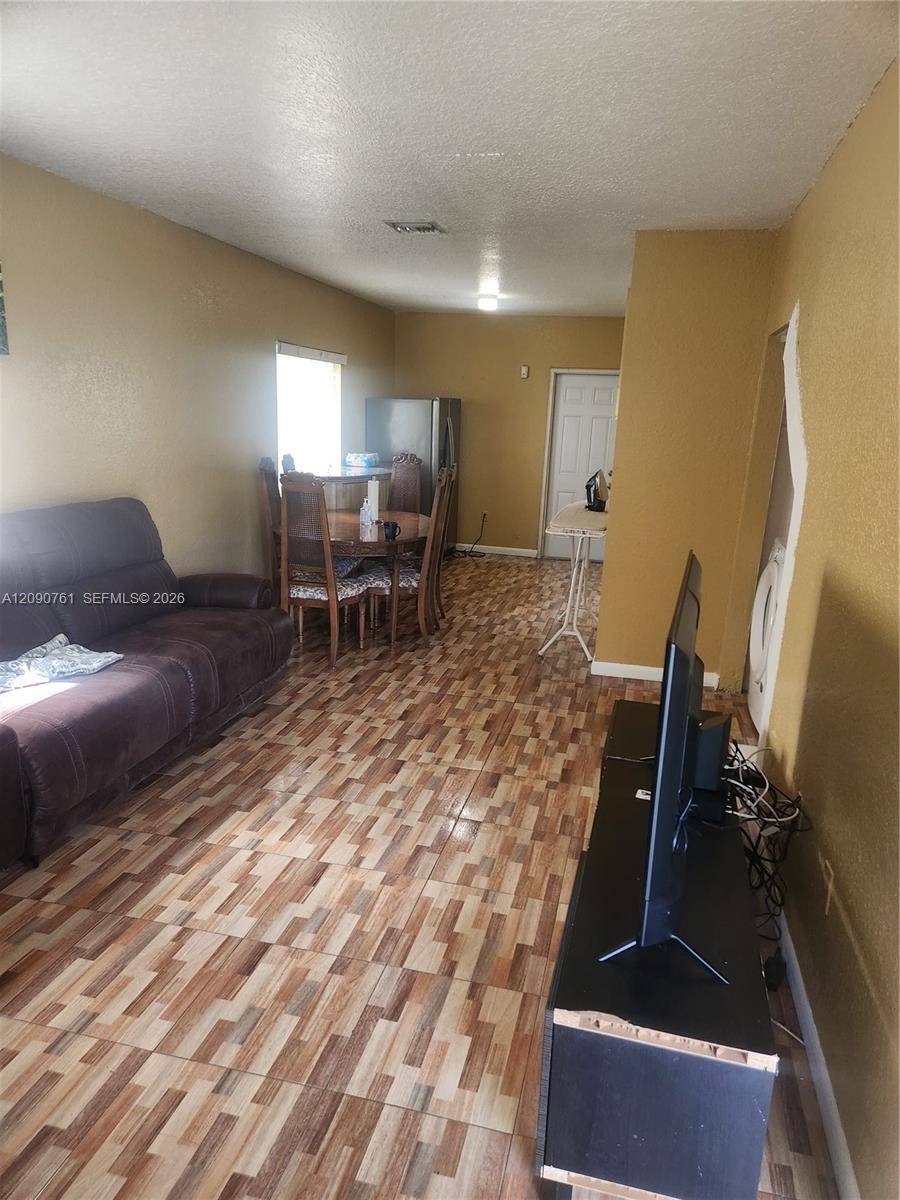 Multipurpose interior space featuring patterned tile flooring and a single-panel interior door Multipurpose interior space featuring patterned tile flooring and a single-panel interior door