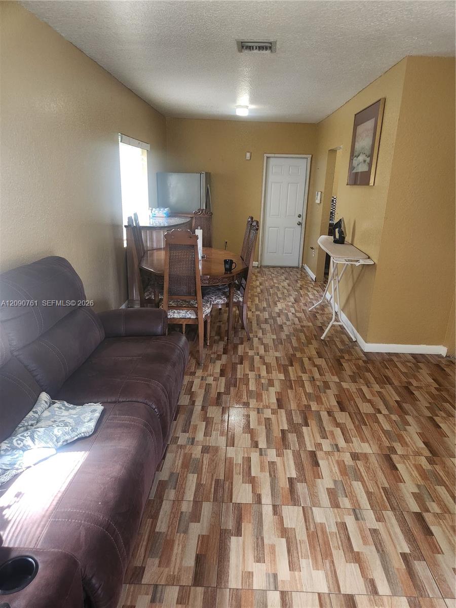 Multi-tonal patterned tile flooring, textured wall finishes, and a single-panel interior door Multi-tonal patterned tile flooring, textured wall finishes, and a single-panel interior door