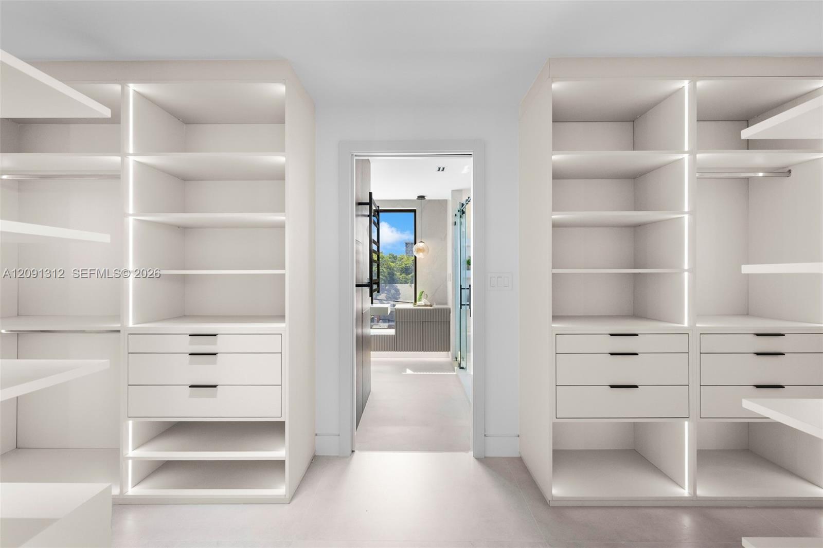 Custom floor-to-ceiling built-in cabinetry featuring integrated vertical LED lighting, matte black hardware, and soft-close drawers