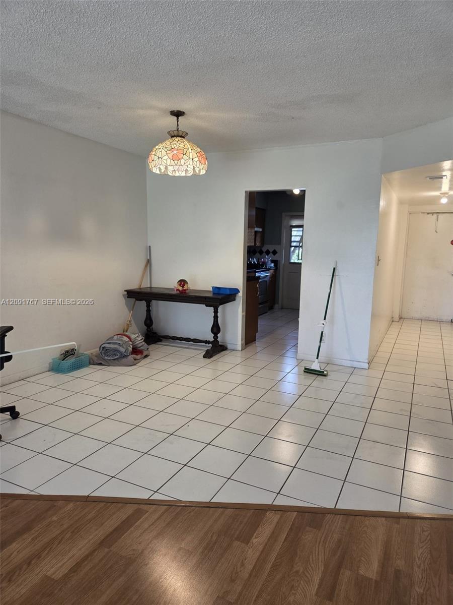 Ceramic tile flooring, drop-in decorative pendant lighting, and wood-finish flooring