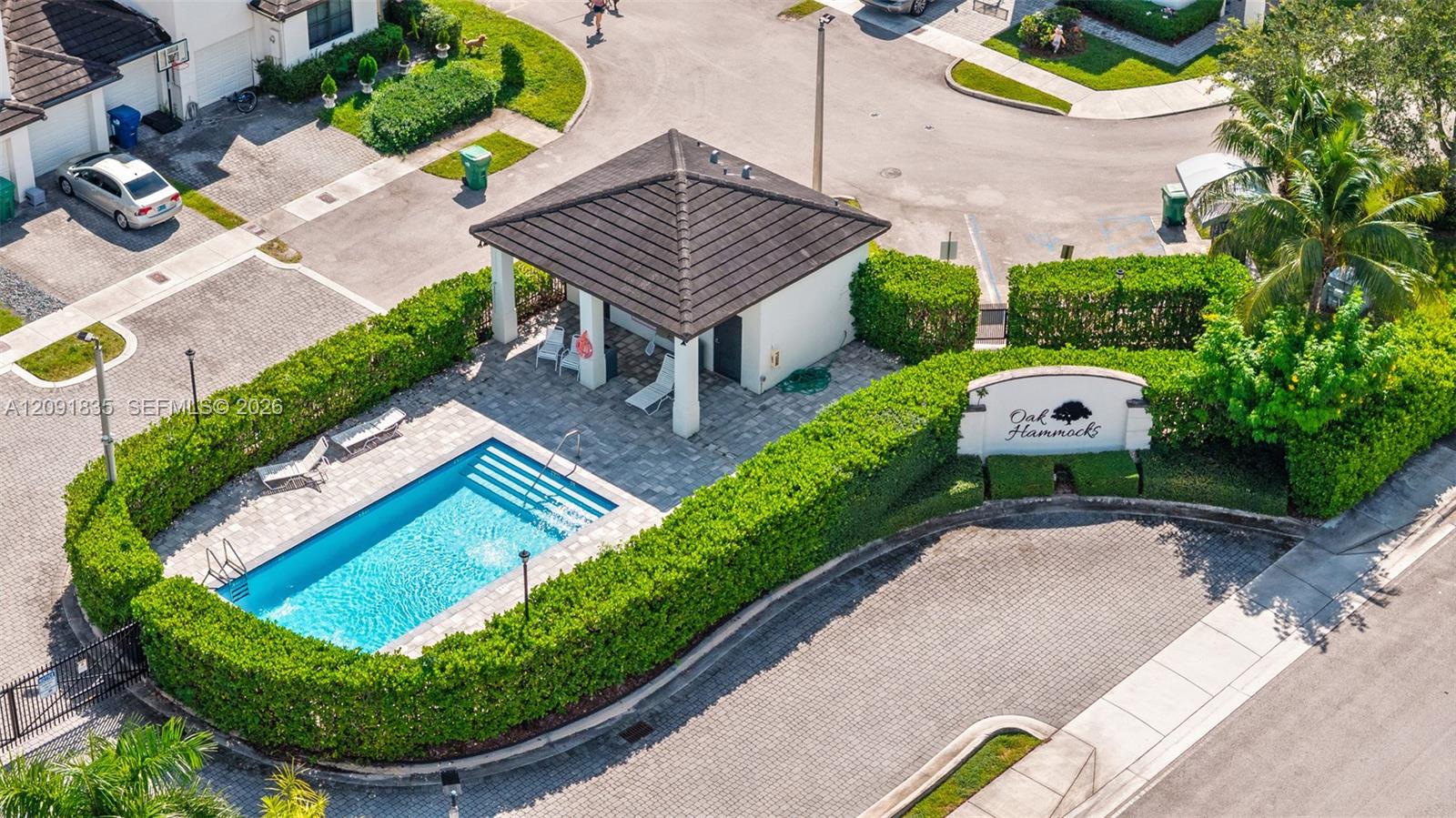 Community amenities including a swimming pool, paved sundeck, covered pavilion, and privacy hedges