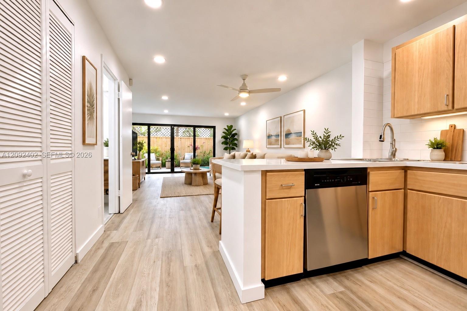 Virtually staged furniture. Quartz countertops, stainless steel dishwasher, wood-finish flooring, and recessed ceiling lighting.