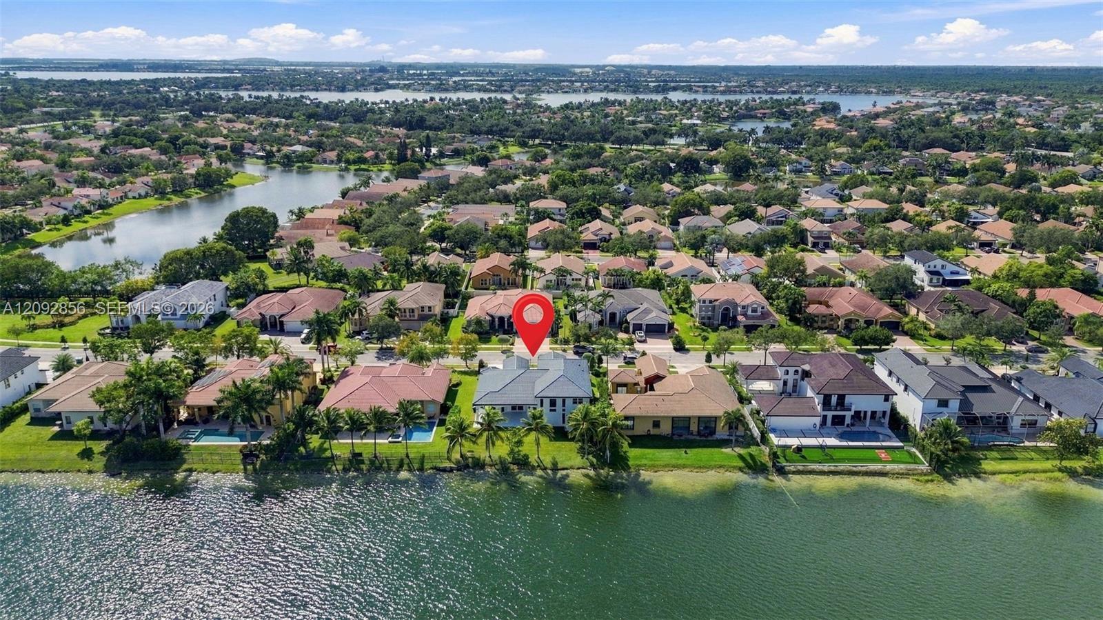 Waterfront residence featuring a tiled roof, multi-level architectural exterior, and direct access to the lake