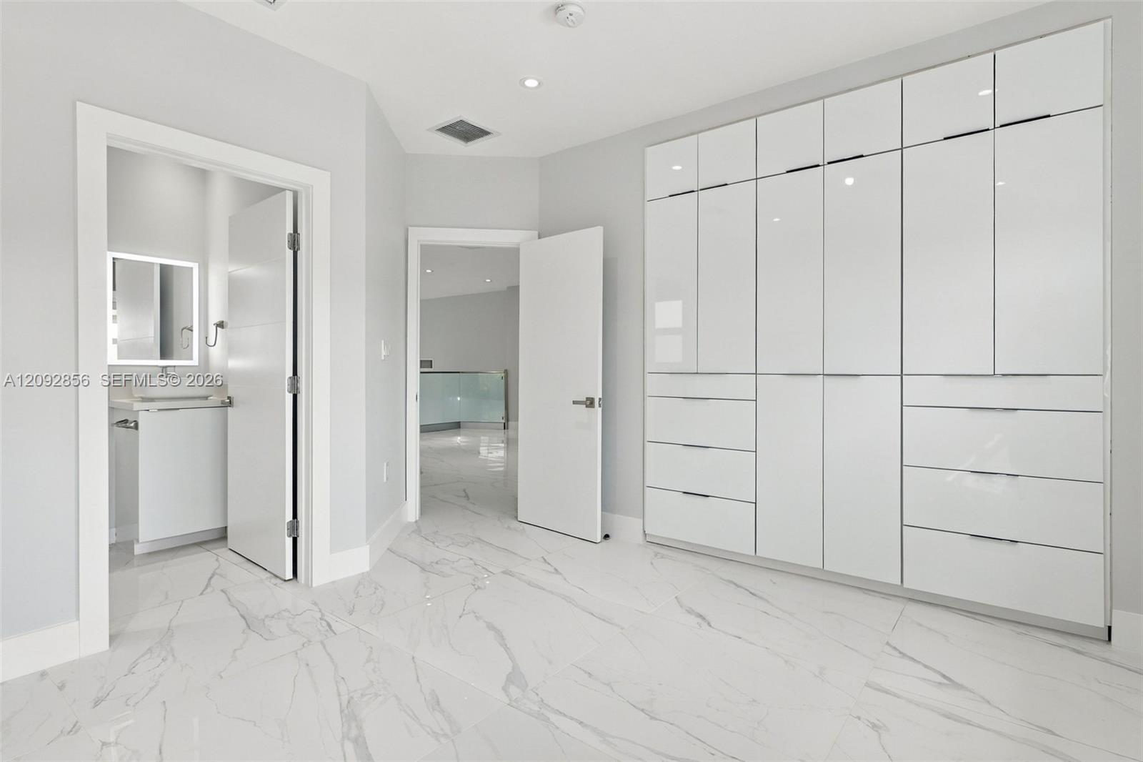 4th bedroom with In suite bathroom - 2nd floor - Custom floor-to-ceiling high-gloss cabinetry, large-format stone-finish floor tiles, and recessed lighting