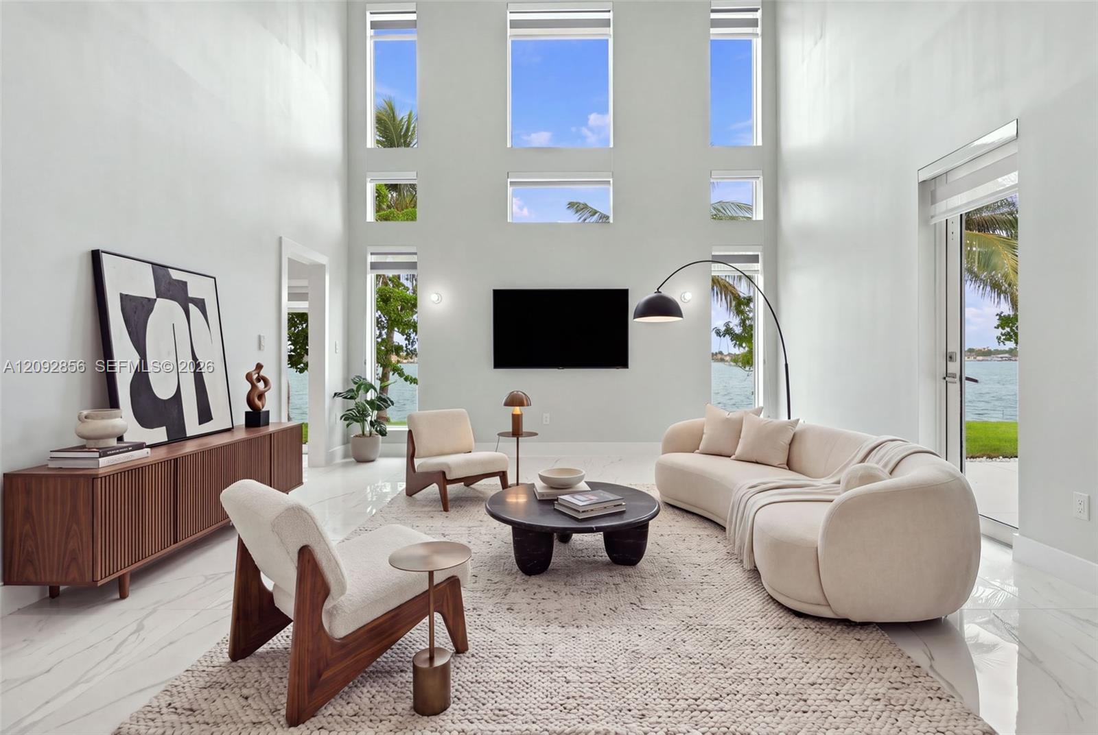 Virtually staged - Double-height ceiling, floor-to-ceiling windows, polished stone-finish flooring, and glass door access
