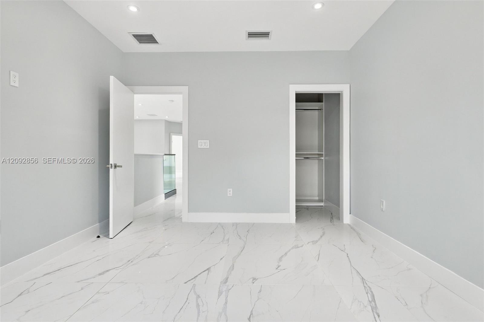 3rd bedroom - 2nd floor - Interior space featuring large-format tile flooring with a neutral veined pattern, recessed ceiling lighting, and a built-in closet with integrated shelving