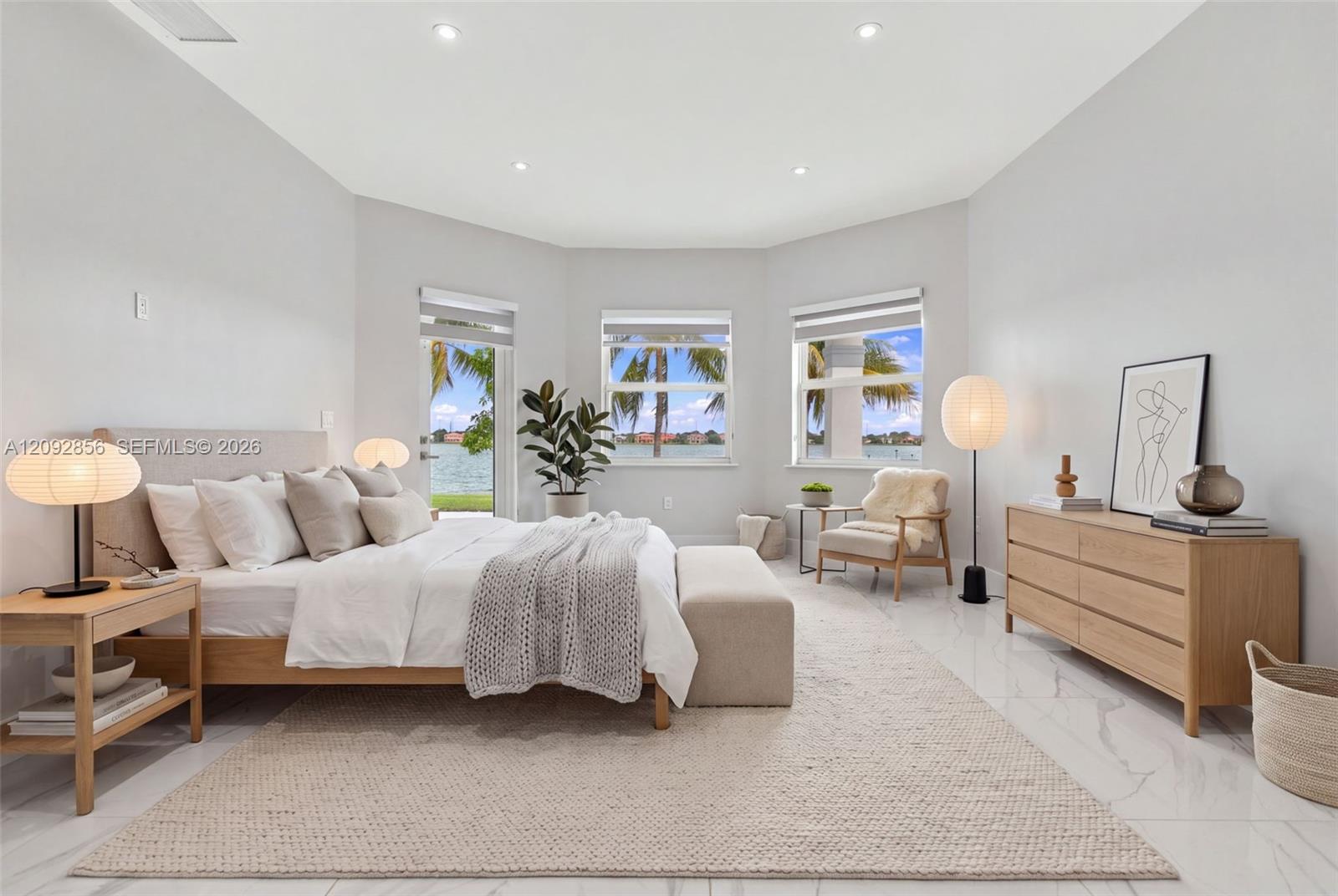 Virtually staged - Spacious bedroom featuring large-format stone flooring, recessed lighting, and a bay window configuration providing exterior water access and scenery