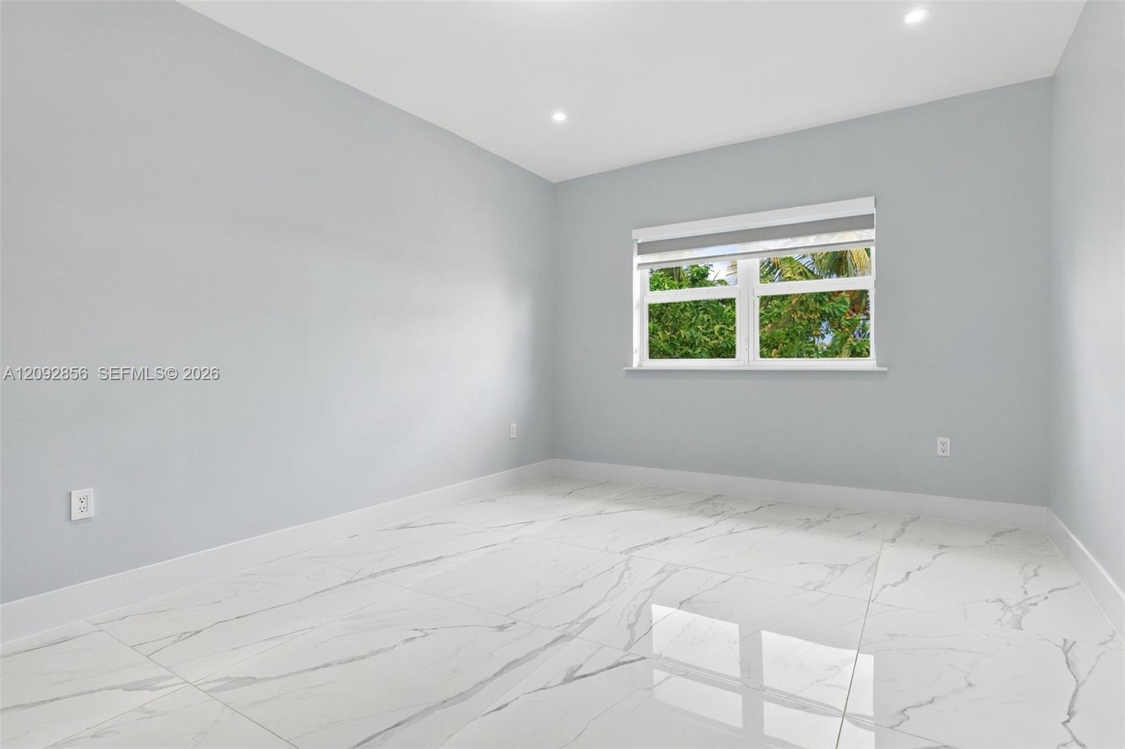 3rd Bedroom - 2nd floor - Neutral interior room featuring polished stone-finish flooring with grey veining, recessed lighting, and a window with white trim