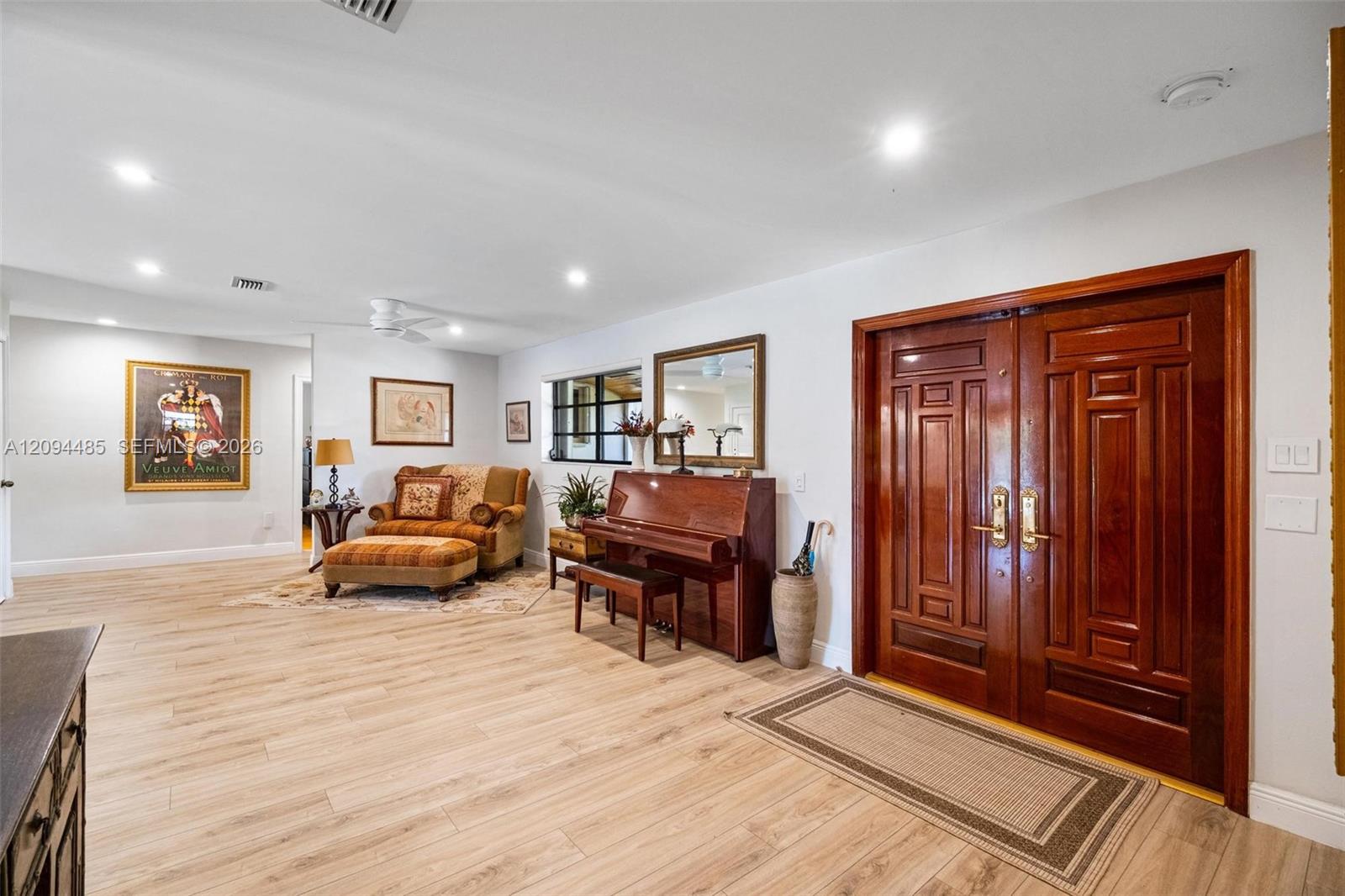 Double-entry front doors with polished wood finish, wood-finish flooring, and recessed ceiling lighting Double-entry front doors with polished wood finish, wood-finish flooring, and recessed ceiling lighting