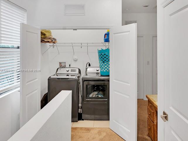 Laundry closet featuring dual-panel doors, wire shelving, and tile flooring